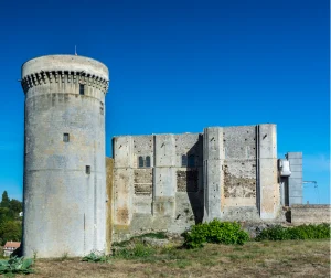 Vue extérieure du Château de Falaise sous un ciel bleu, mettant en valeur son architecture médiévale et sa tour principale.